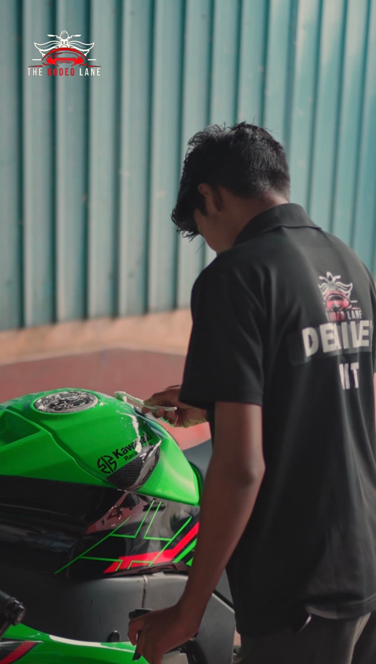 Technician washing a green motorcycle at The Rodeo Lane studio